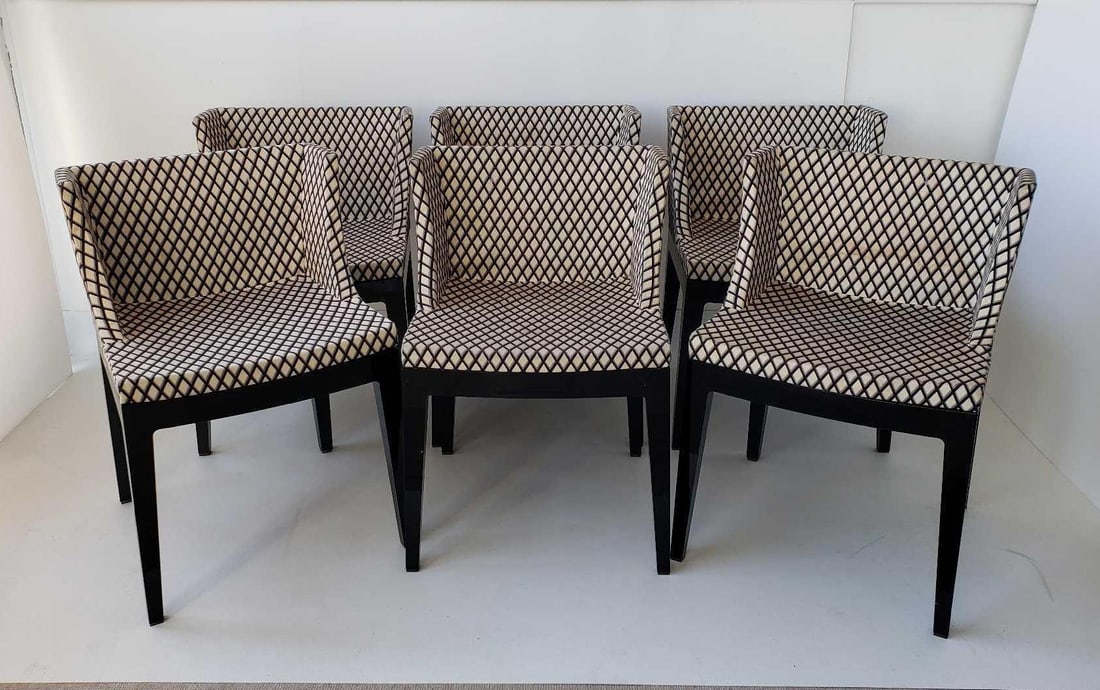 SIX PHILIPPE STARCK FOR KARTELL MADEMOISELLE CHAIRS (Lot 1 of 2): Six Mademoiselle chairs designed by Philippe Starck for Kartell are shown. These chairs feature a black frame and are upholstered in a fabric with a repeating diamond harelquin pattern in shades of be