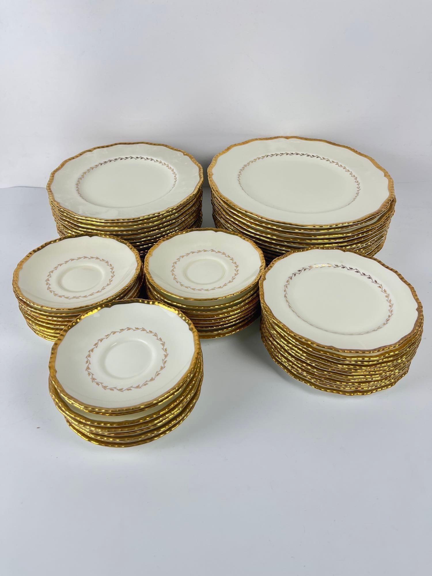 VALUE LOT: 62 PIECE PLATE SET OF ROYAL DOULTON BELVEDERE: This is a 62-piece plate set of Royal Doulton Belvedere tableware. The set includes various sizes of plates and saucers, all featuring a white base with an ornate, textured gold rim and a subtle inner
