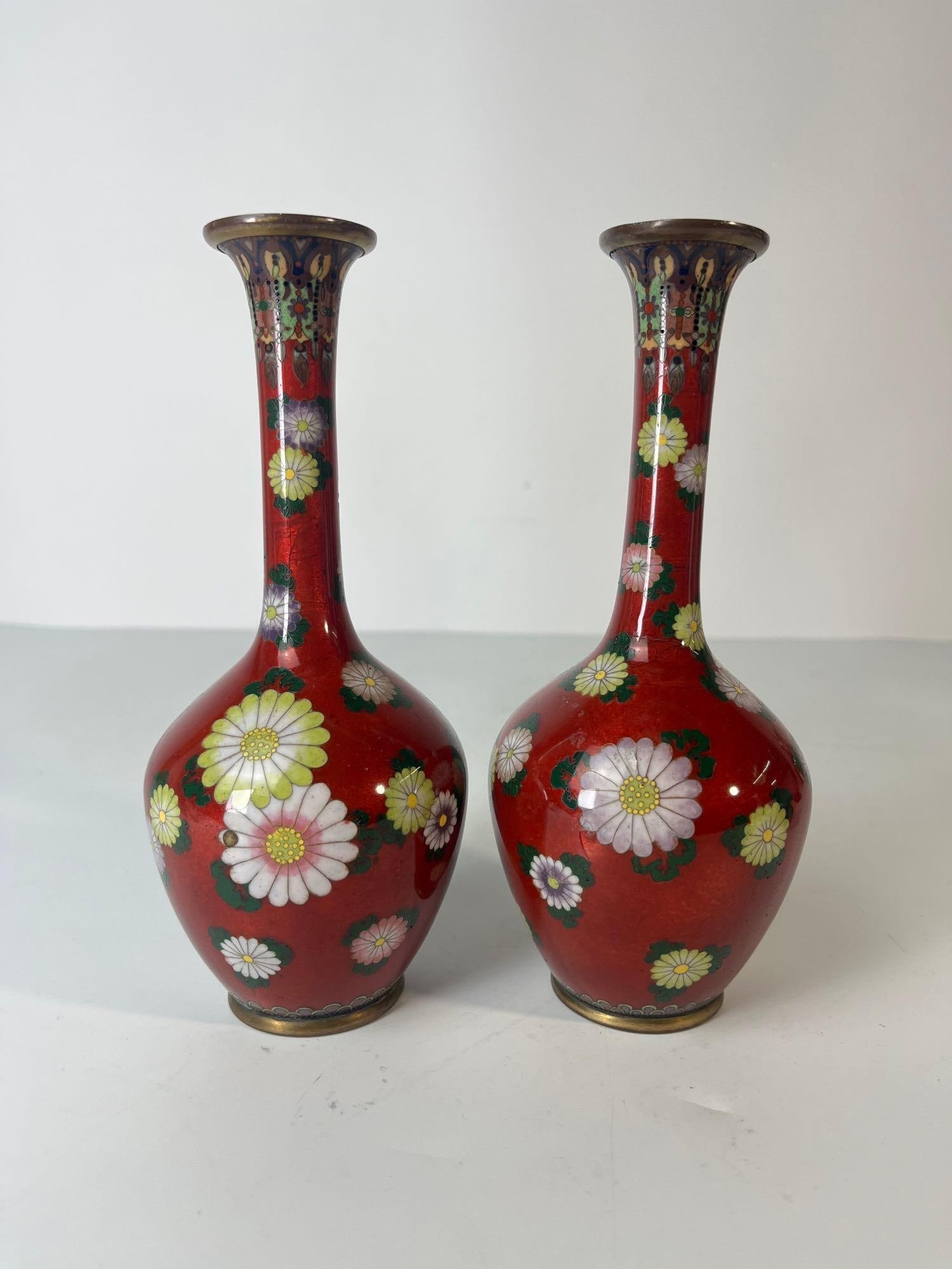 PAIR OF EXQUISITE JAPANESE RED CLOISONNE BUD VASES: A pair of exquisite Japanese red cloisonné bud vases, adorned with intricate floral and bird motifs. Dimensions: 7.5" H Artist or Maker: Unknown Notes: Although care is taken to photograph and