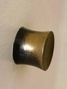 TWI PAIR OF VINTAGE BRUTALIST STYLE SOLID BRONZE DOOR KNOBS: A set of three vintage Brutalist-style brass door knobs, each featuring a cylindrical design with a flared end, showing a distinctive aged patina. From the Moschino NYC showroom. Dimensions: 2" DIA