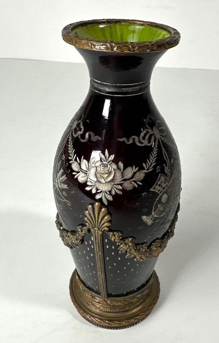 UNIQUE OXBLOOD BRONZE MOUNTED GLASS VASE LIKELY FRENCH: This unique vase features striking oxblood red opaline glass gracefully mounted on an ornate bronze base, suggesting a likely French origin. The warm hue of the glass, combined with the intricate met
