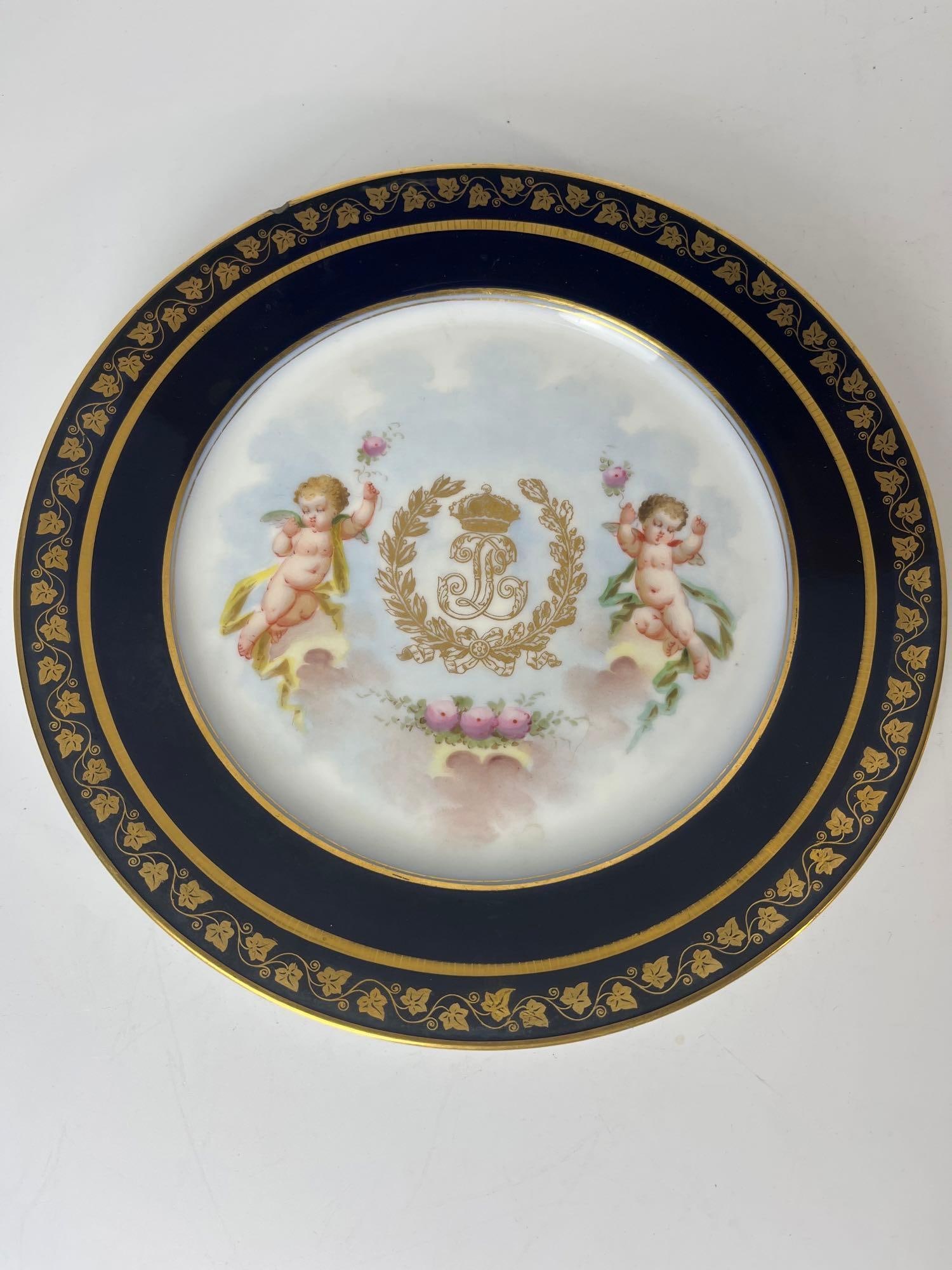 SEVRES CHATEAU DES TUILERIES CUPID PLATE: Featuring delicate hand-painted depictions of Cherubs in a romantic scene, surrounded by lavish gilding and rich borders. Bearing the distinctive marks of the Sèvres manufactory and the royal residen