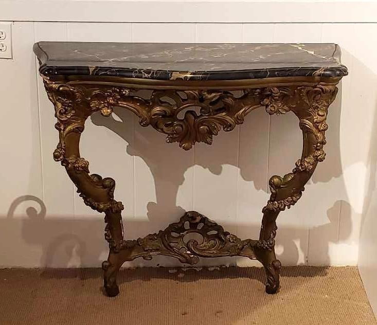 ORNATE ANTIQUE FRENCH LOUIS XV STYLE GILTWOOD DEMILUNE CONSOLE TABLE WITH BLACK MARBLE TOP: An ornate antique French Louis XV style demilune console table, crafted from gilt wood and featuring a black marble top. Dimensions: 32"h x 38.5"w x 18.5"d Artist or Maker: Unknown Not