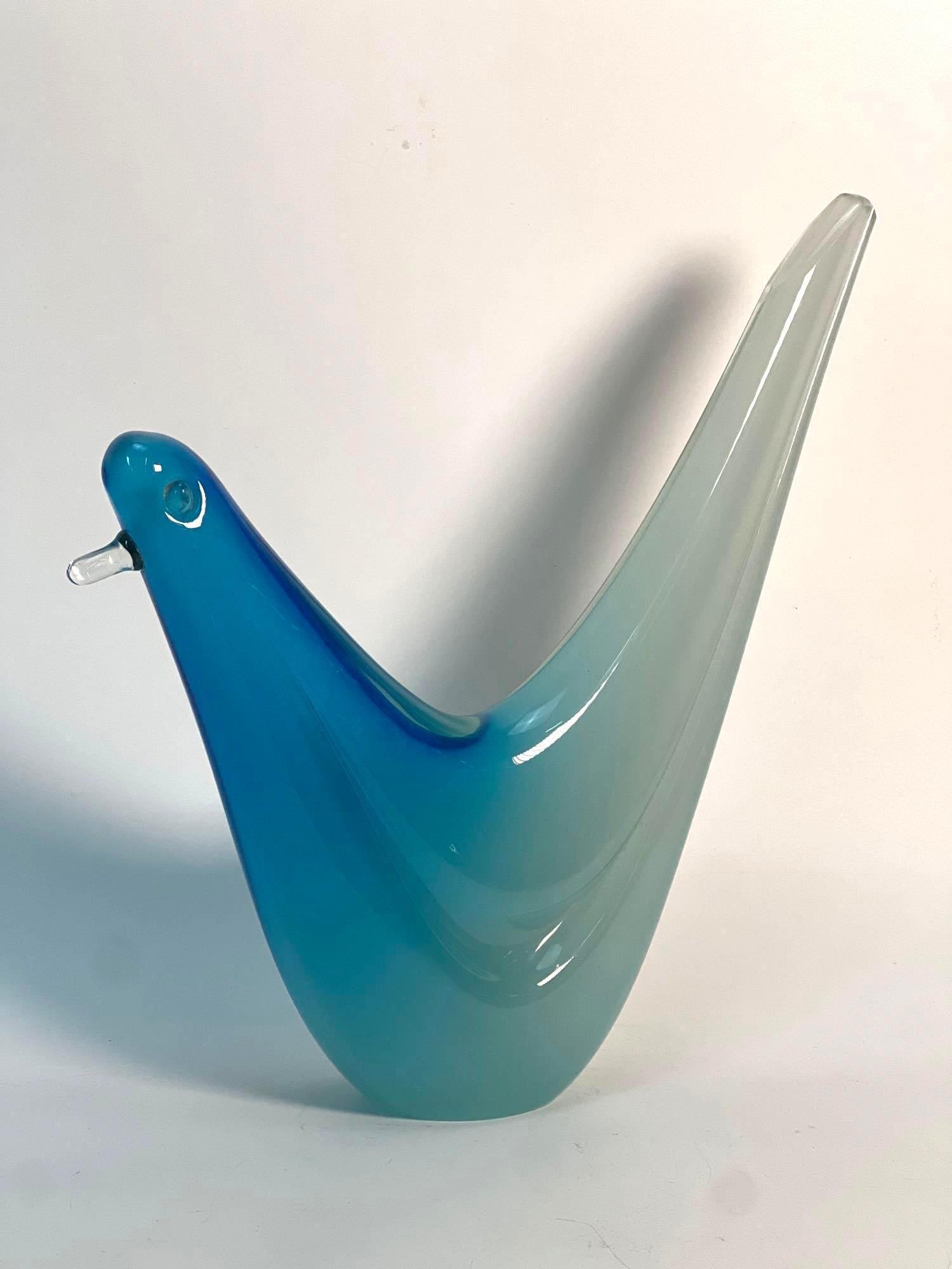 MURANO-STYLE VENETIAN ART GLASS BIRD SCULPTURE: A Murano-style Venetian art glass sculpture depicting a stylized bird with a blue body and a long, gracefully curved neck that transitions to a lighter, translucent shade. Dimensions: 11.25" Artist or