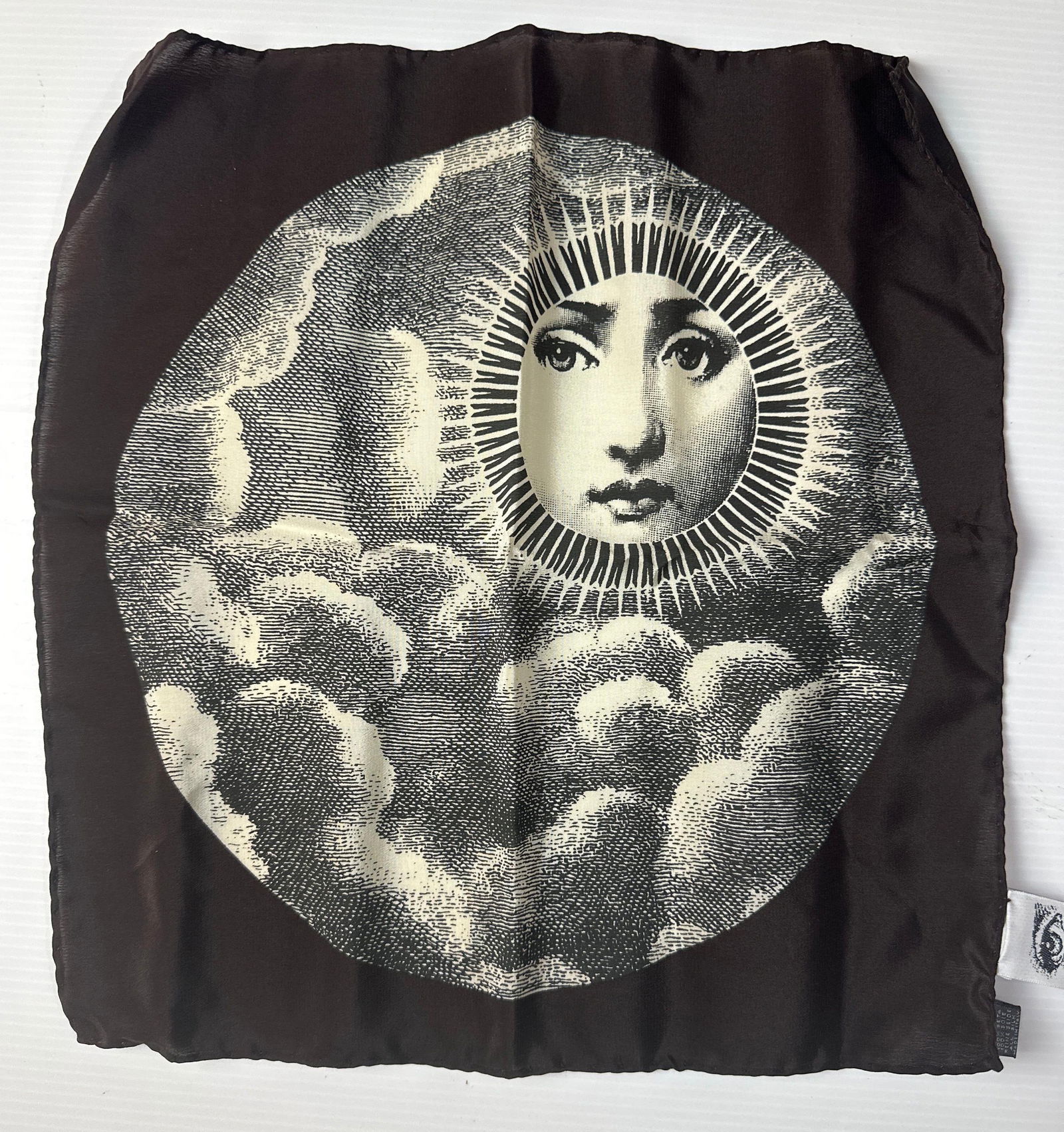 VINTAGE FORNASETTI SILK HANDKERSCHIEF TEMA E VARIAZONE 101: A monochromatic printed scarf with stylized sun and cloud pattern. Dimensions: 12" x 12" Maker/Artist Fornasetti Notes: Although care is taken to photograph and describe the item, absence of a condi