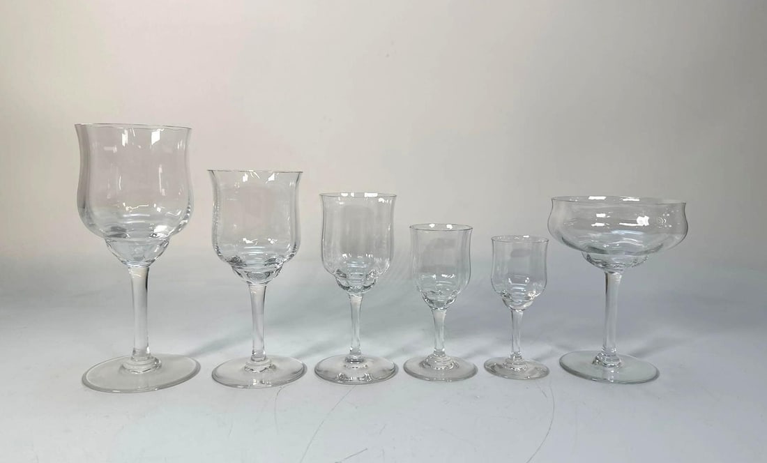 MASSIVE SET OF BACCARAT CRYSTAL CAPRI OPTIC GLASSWARE: A Baccarat Crystal Capri Optic glassware collection, featuring numerous clear crystal pieces of various shapes including stemmed coupes, goblets, and tumblers, all exhibiting a distinct ribbed or opti