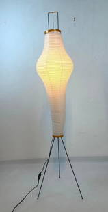 AUTHENTIC AKARI LIGHT SCULPTURE BY ISAMU NOGUCHI: A paper floor lamp on a tripod base with Noguchi mark. Note tiny puncture in photo.  Dimensions: 66&#34; TALL X 13&#34; DIA  Maker: Noguchi  Provenance: A New York Collector  Notes: Although care