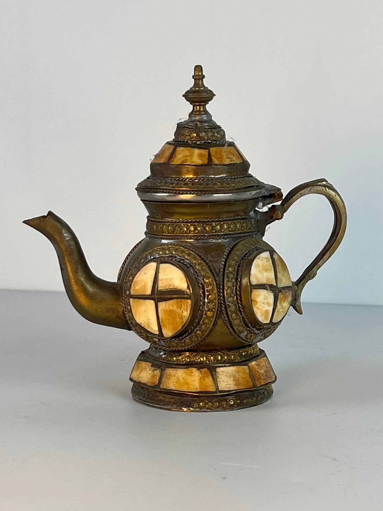 VALUE LOT: ANTIQUE BRASS/ BONE TEA POT: ANTIQUE BRASS/ BONE TEA POT Moroccan Style Brass & Bone Tea Pot Dimensions: 7"T X 3.5"W X 7"D Artist or Maker: Unknown Provenance: From the estate of a nonagenarian New York private co