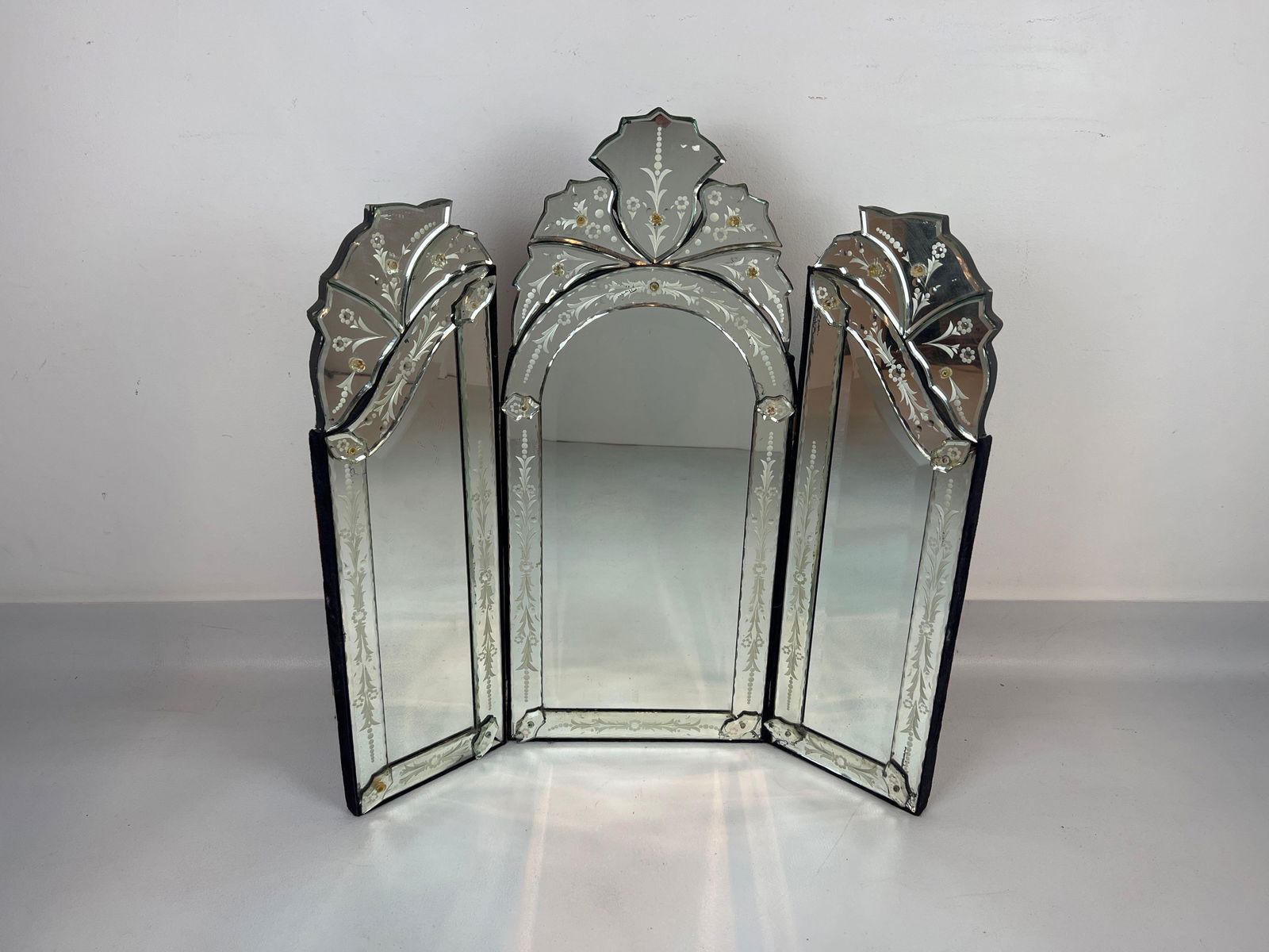 VINTAGE TRI-FOLD VENETIAN MIRROR IN THE STYLE OF VIVAI DEL SUD: A tri-fold hanging mirror with a frosted, etched pattern. Dimensions: 30” x 29.5” Maker: Unknown Provenance: A New York Collector Note: Although care is taken to photograph and d