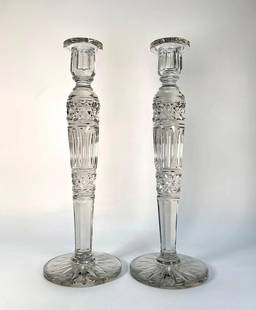 MONUMENTAL STEUBEN ATTR. TWIN CRYSTAL CANDLESTICKS: An oversized pair of twin crystal candelabras. Each candelabra is crafted from clear, cut crystal, showcasing a traditional columnar design with multiple tiers of cut patterns and a wide, stable base.