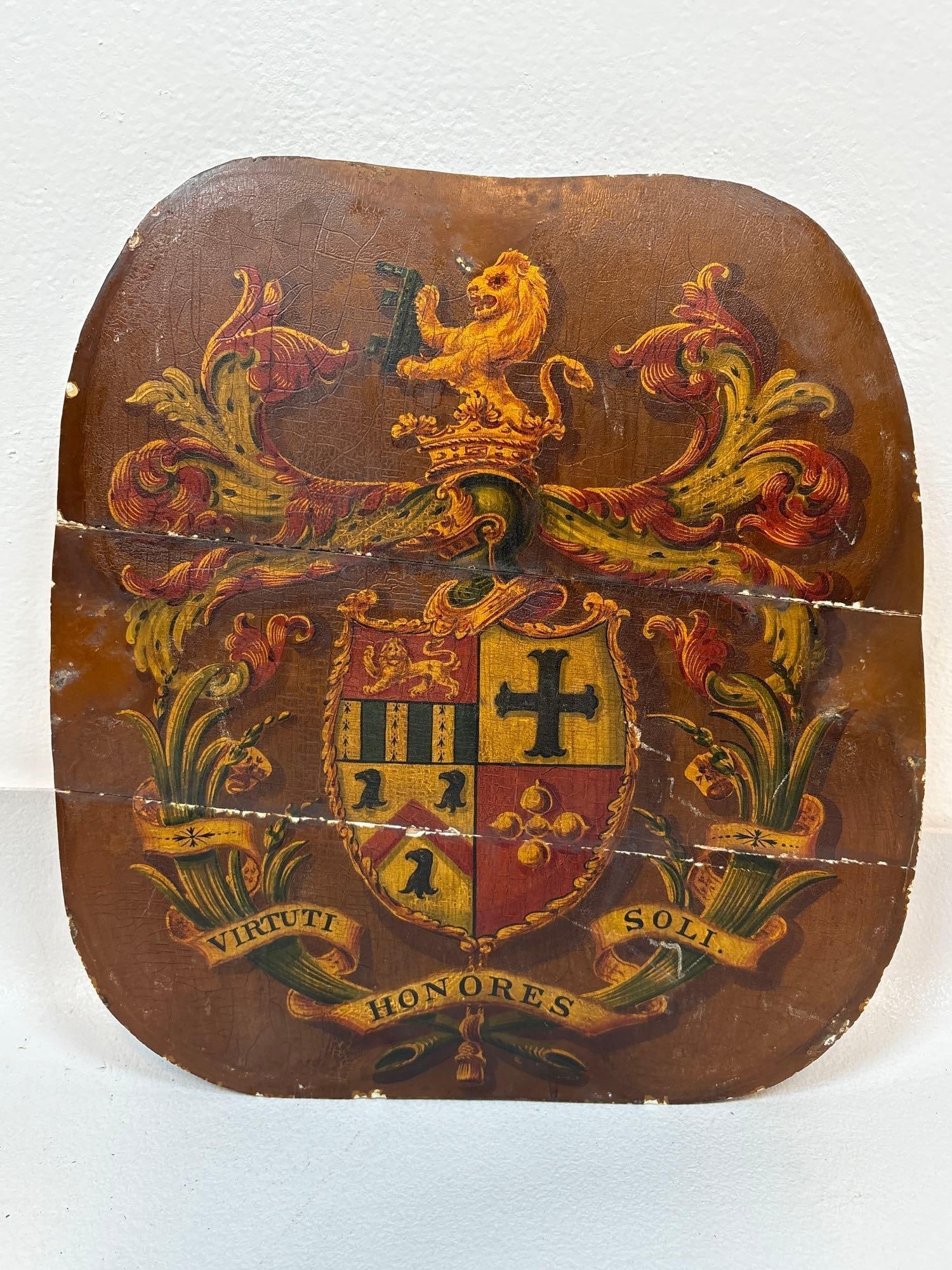 ANTIQUE HAND-PAINTED WOODEN COAT OF ARMS PANEL / HALL CHAIR SEAT: A antique hand-painted wooden coat of arms panel. (former hall chair seat panel?) The panel features hand-painted heraldic design, displaying a coat of arms with a lion, a cross. A banner at the botto
