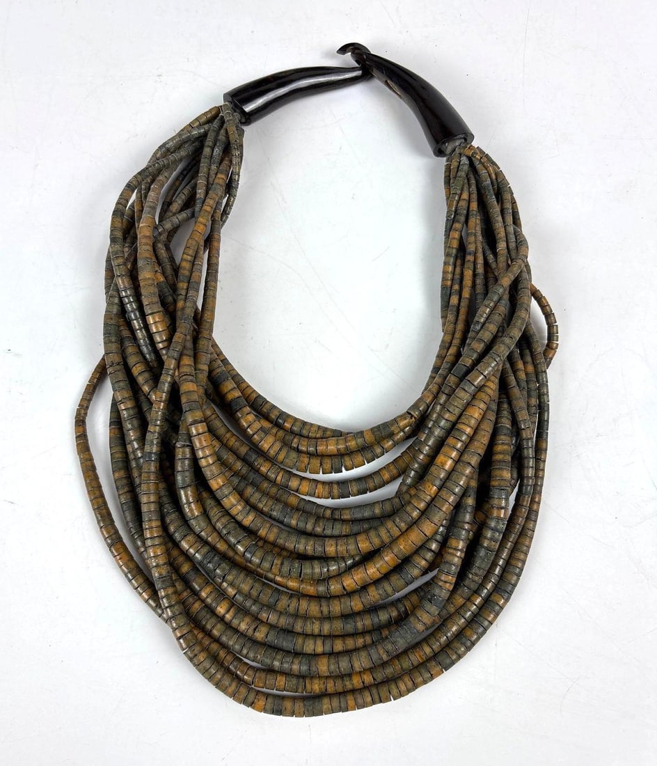 GERDA LYNGGAARD MONIES BONE NECKLACE: A multi-strand necklace made from numerous cylindrical bone beads with a mottled gray, brown, and yellow finish. Dimensions: 12"L from bottom to clasp Artist or Maker: Gerda Lynggaard Provenan