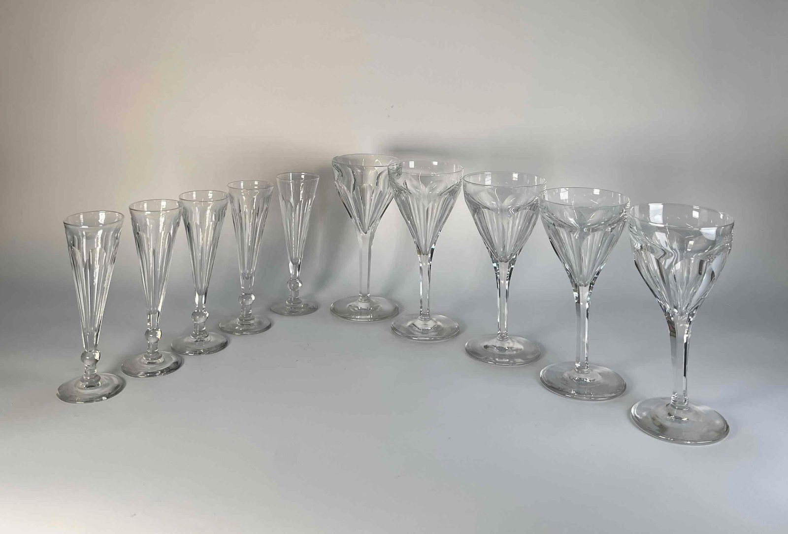SET OF VINTAGE VAL SAINT LAMBERT FACETED CRYSTAL STEMWARE: A set of vintage Val Saint Lambert faceted crystal stemware, featuring Champagne Flutes and Wine Glasses with distinctive cut designs. Dimensions: Highest- 7.75" H Artist or Maker: Val Saint Lam