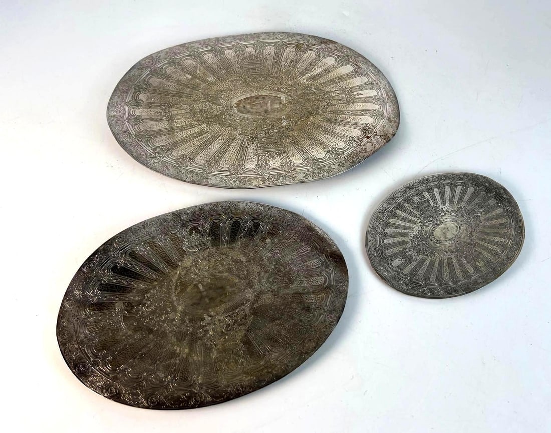 SET OF THREE ANTIQUE SILVER-TONE ORNATE DECORATIVE REED AND BARTON EMBOSSED TRIVETS: *A set of three silver-tone decorative chargers / underplates / Trivet / coaster. Each oval-shaped plate features an intricate, embossed pattern and an aged, darkened patina. Dimensions: SMALL - 4.7