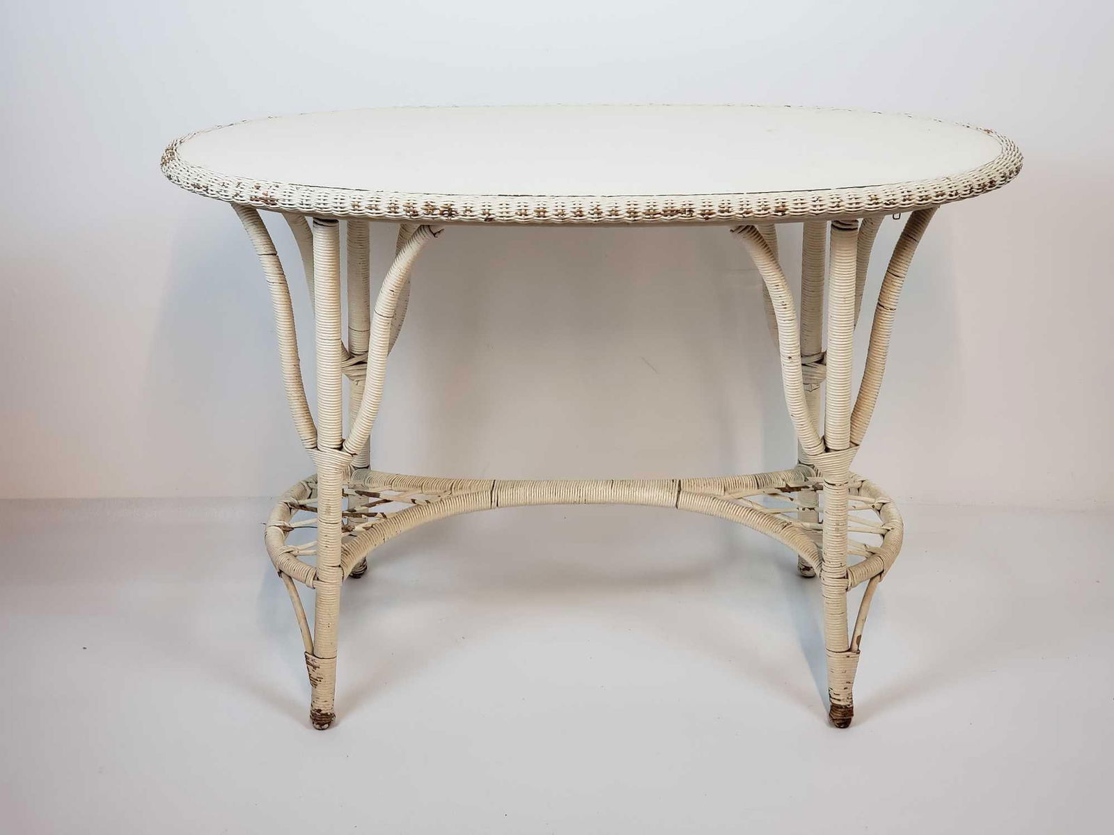 VINTAGE WEATHERED OVAL WICKER RATTAN CONSOLE/ HALL TABLE: *A vintage oval wicker rattan console or hall table. Dimensions: 30.25"h x 43.25"w x 19.75"d Artist or Maker: Unknown Provenance: N/A Notes: Although care is taken to photograph and describ