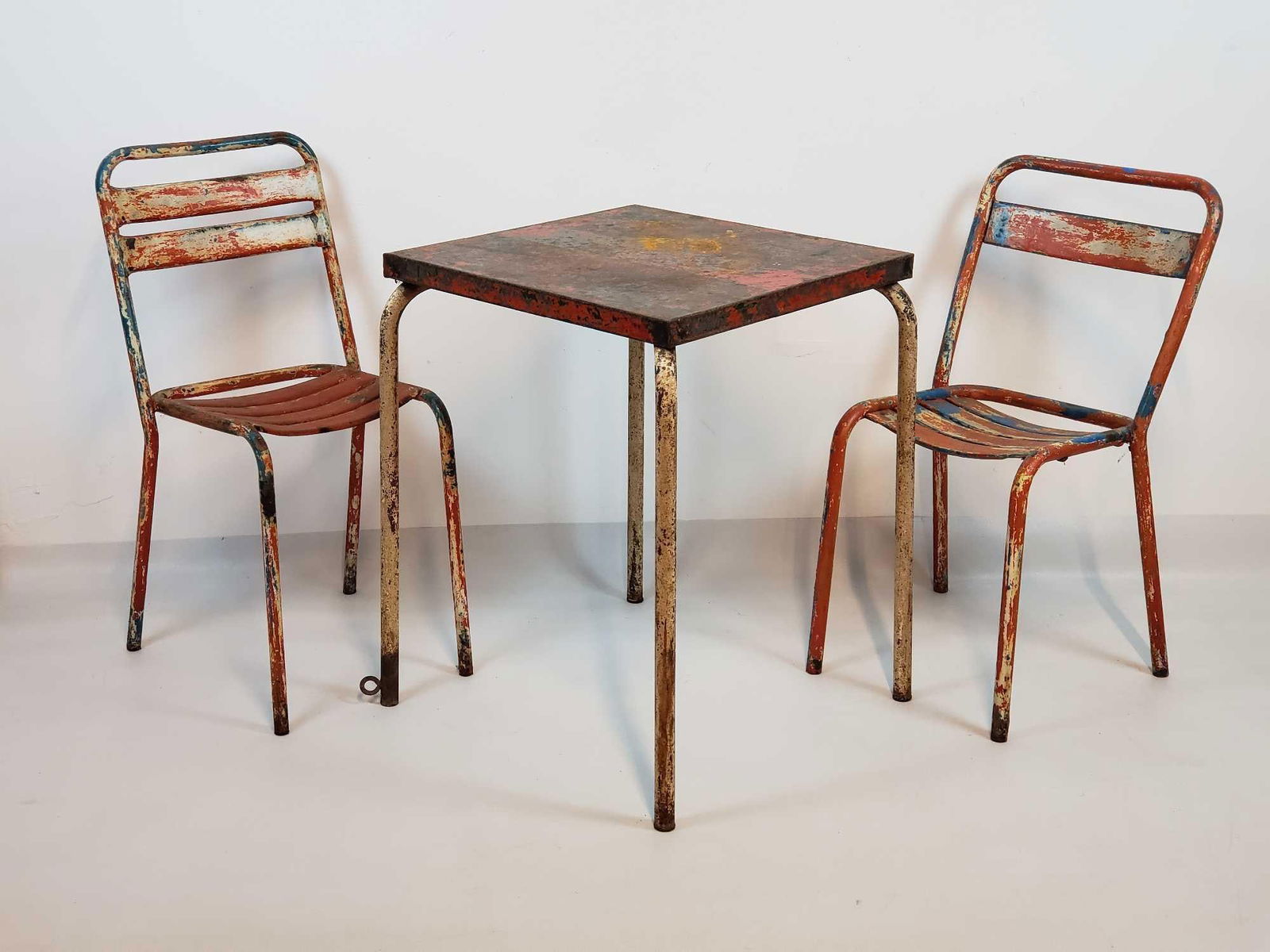 VINTAGE DISTRESSED METAL CAFE TABLE ATTRIBUTED TO JEAN PROUVE AND TWO STACKING METAL CHAIRS (1 of 13)