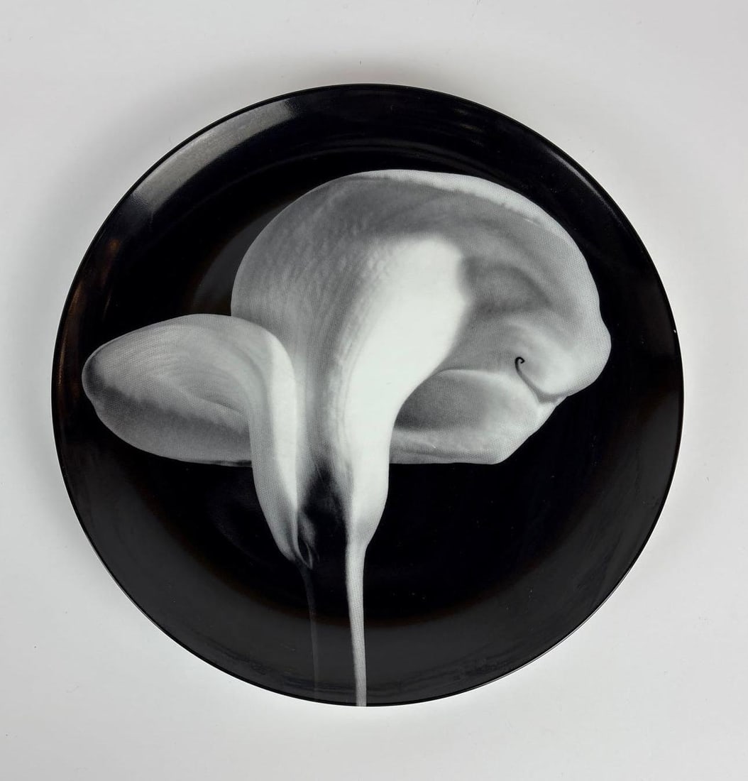 ROBERT MAPPLETHORPE FOR SWID POWELL "CALLA LILY,1984" LIMOGES PORCELAIN PLATE: A porcelain plate by photographer Robert Mapplethorpe Dimensions: 12" dia Maker: Swid Powell Provenance: Property of an Upper East Side, NYC estate. Notes: Although care is taken to photograph and d