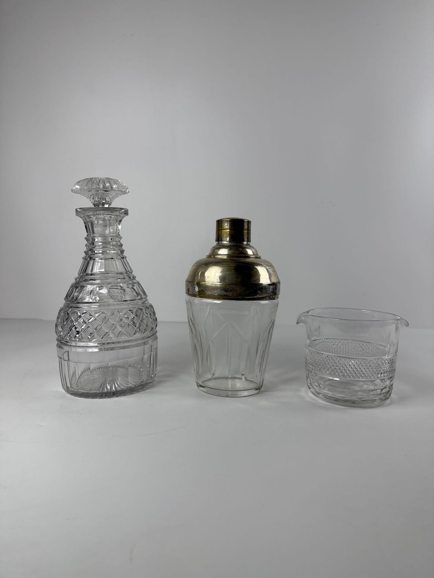 VALUE LOT SET OF THREE (3) BAR WARE ITEMS: *Vintage and antique cut glass and crystal barware items. Inlcudes decanter, silver plated cocktail shaker, and antique wine rinser. Dimensions: Tallest: 10.5” x 5” dia Artist or Maker:
