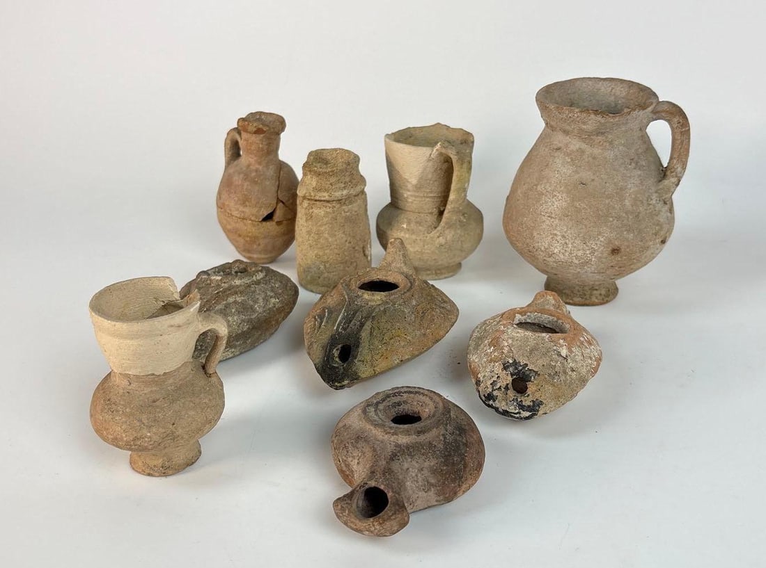 ANCIENT ROMAN / BYZANTINE POTTERY LOT INCL OIL LAMPS, JUG, AND JUGLETS: A lot of fifteen ancient glass vessels. Dimensions of largest: 4.5" h x 3" Maker: Unknown Provenance: A New York City Ivy League Scholar and Collector. Notes: Although care is taken to photograph a