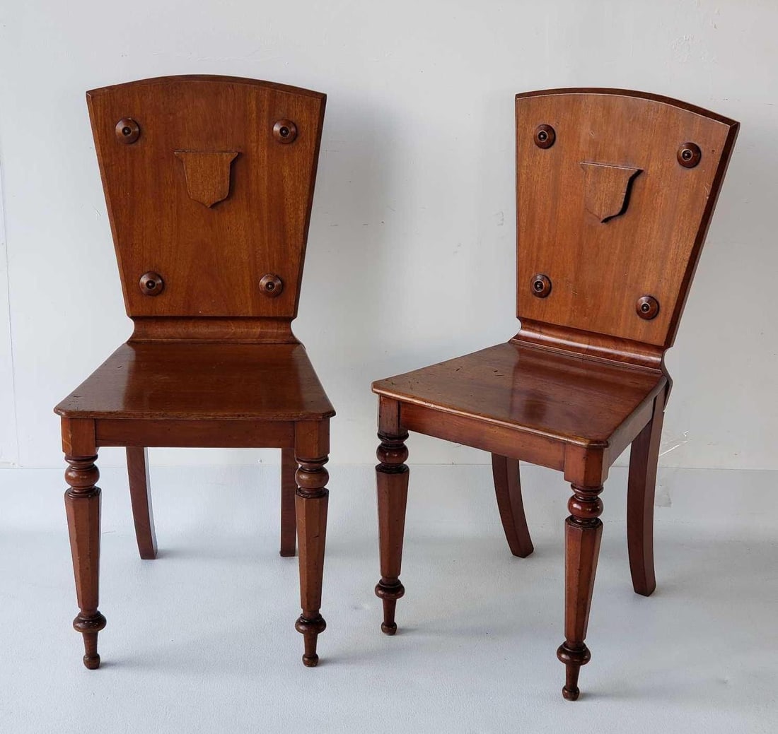 PAIR OF REGENCY STYLE MAHOGANY HERALDIC HALL CHAIRS WITH SHIELD AND BULLSEYE EMBELLISHMENTS (1 of 19)