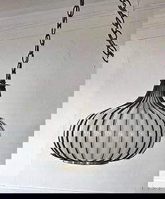 MID CENTURY MODERN, HOLLYWOOD REGENCY ONION/GARLIC CAGED MILK GLASS SWAG PENDANT LIGHT: A mid-century modern pendant lamp in the form of garlic with white glass blown into the vertically ribbed brass frame. Possibly manufactured by Lightcraft of California. Comes with hanging chain. Dim