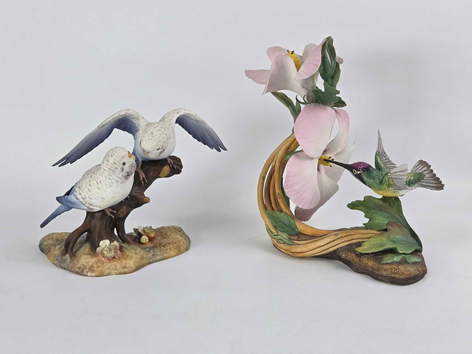 LOT OF TWO FINE PORCELAIN BIRD GROUPS: BOEHM HUMMINGBIRD AND ROYAL CROWN DERBY BUDGIES: A pair of bird-themed sculptures Dimensions: 5.5"h and 7.25"h Maker: Boehm Provenance: The Estate of Joseph Rodano Notes: Although care is taken to photograph and describe the item, absence