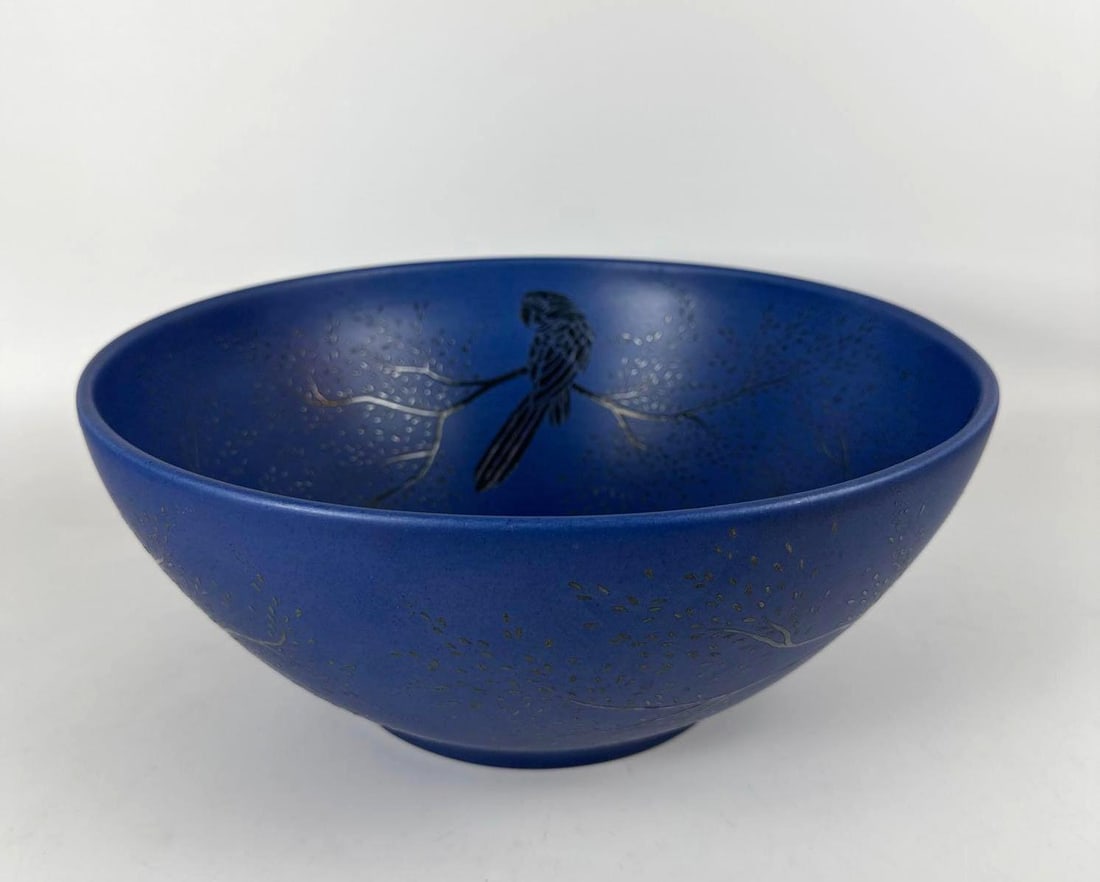 EMILIA CASTILLO PORCELAIN BOWL WITH SILVER INLAY, TREES & BIRDS DESIGN, SIGNED: This is a Emilia Castillo porcelain bowl in deep matte blue featuring a delicate silver inlay design of a perched bird and branches, and it is signed by the artist. Dimensions: 6”H x 13”W