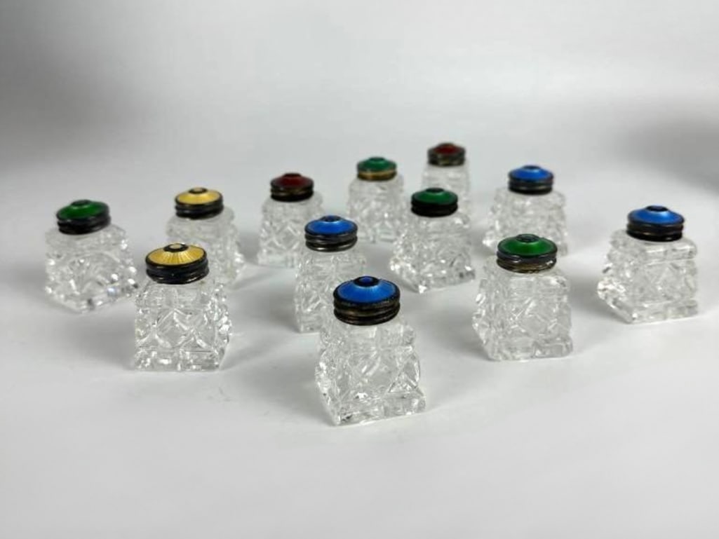 SET OF 12 STERLING AND GUILLOCHE ENAMELED CRYSTAL SHAKERS: A group of 12 1960's sterling & guilloche enameled crystal shakers with square bodies. Dimensions: 1.75"H x 1.25"W x 1.25"D Maker: Unknown Provenance: The Estate of Joseph Rodan