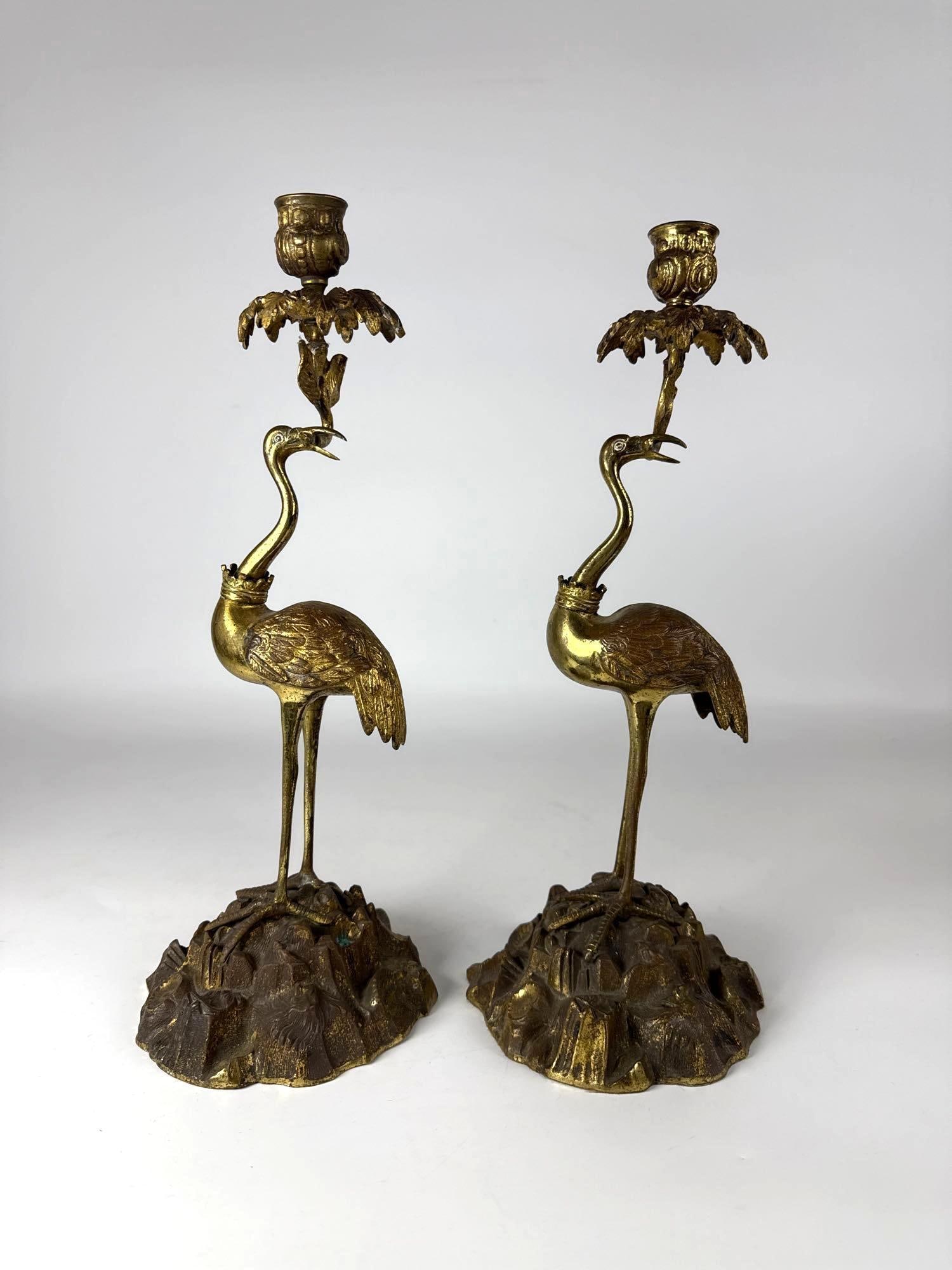PAIR OF ANTIQUE CONTINENTAL GILT BRONZE FLAMINGO BIRD FORM CANDLE HOLDERS: Pair of 19th century gilt bronze candlestick holders with flamingos on rocky base. Approximate Dimensions: 15” Tall x 4.5" dia Maker: Unknown Notes: Although care is taken to photograph an