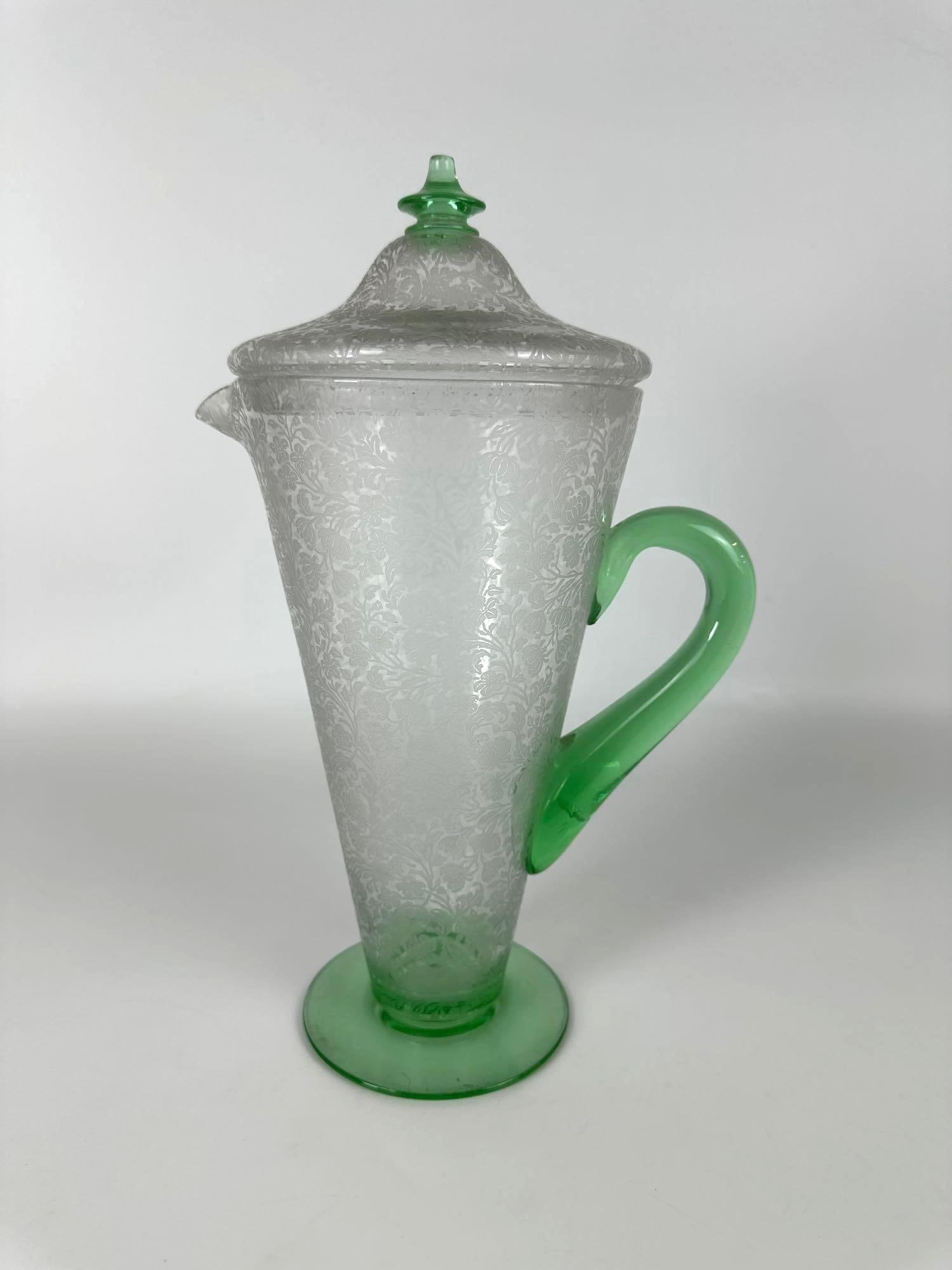 URANIUM GLASS EWER PITCHER: Engraved glass ewer pitcher with cover Approximate Dimensions: 14" h x 6" dia Artist or Maker: Unknown Provenance: From a New York City Collector Notes: Although care is t