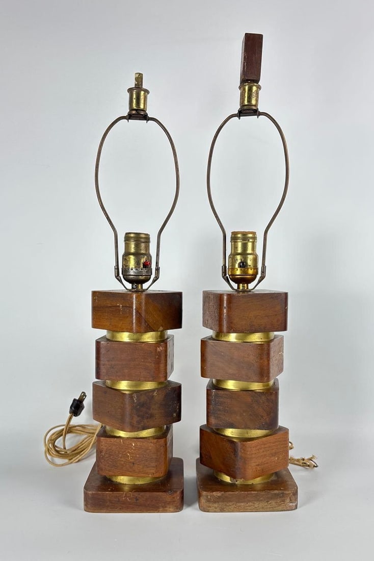PAIR OF MID-CENTURY MODERN STACKED WALNUT AND BRASS LAMPS: *This is a matching pair of table lamps constructed from alternating square-cut walnut wood and polished brass cylindrical spacers, stacked in a staggered, twisted column on a square wood base. Appro