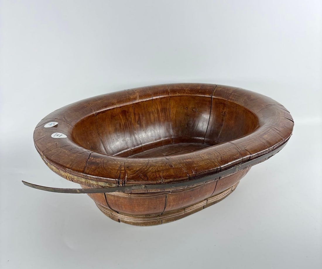 ANTIQUE CHINESE WOOD BABY BATH: An antique Chinese baby bath crafted from bent hardwood, reinforced with metal bands. Approximate Dimensions: 20” x 17” x 7” Artist or Maker: Unknown Provenance: A New York Collec