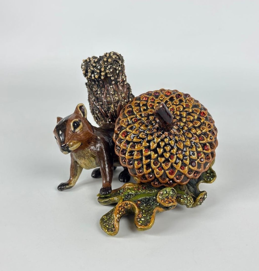 JAY STRONGWATER EMBELLISHED SQUIRREL AND ACORN DESK CLOCK: Hand-painted enamel over metal squirrel figurine perched beside a Swarovski crystal-encrusted acorn containing a timepiece. Approximate Dimensions: 4"H x 5"Dia Artist or Maker: Jay Strongwater Provena