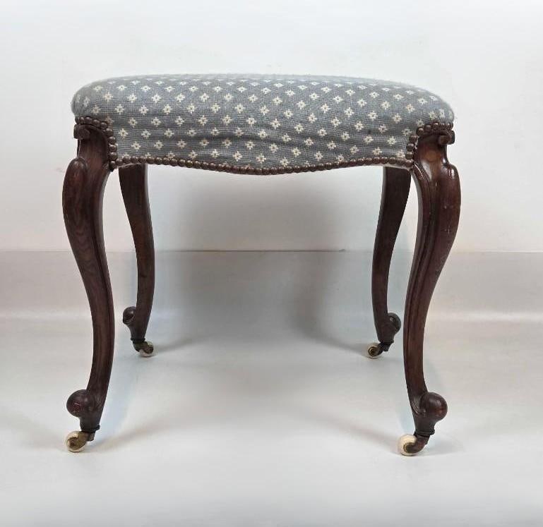 19TH CENTURY FRENCH LOUIS XV STYLE WALNUT UPHOLSTERED STOOL ON CASTERS: Antique carved walnut stool in the Louis XV taste with cabriole legs, brass tack trim, and ceramic casters. Approximate Dimensions: 19"h x 20"w x 20"d Artist or Maker: Unknown Provenance: From a New Y