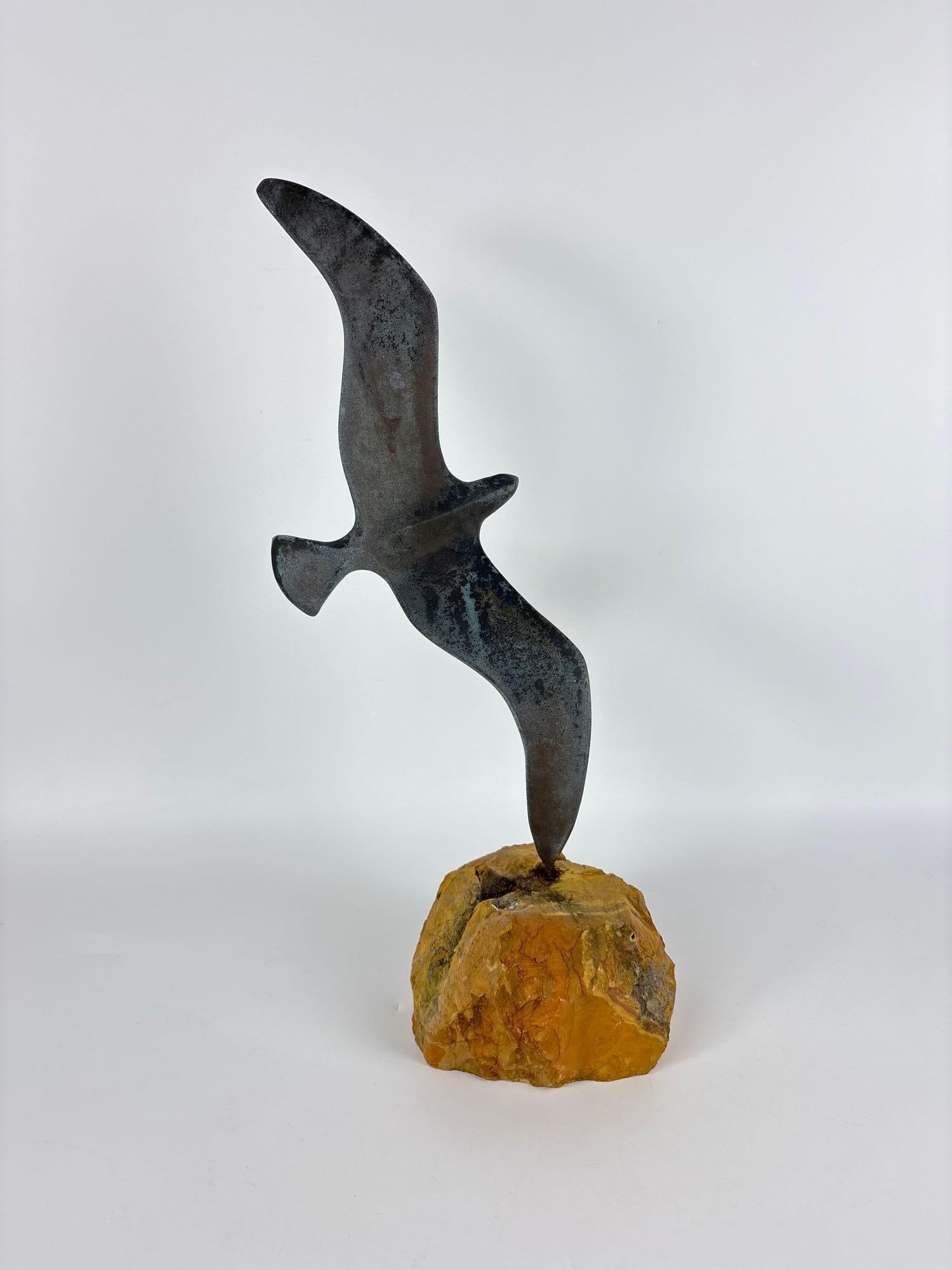 CURTIS JERE STYLE MID CENTURY BRONZE SCULPTURE ON STONE BASE "SEAGULL IN FLIGHT": A patinated bronze, stylized bird figure sculpture mounted to a raw stone foundation. Approximate Dimensions: 19"H Artist or Maker: Unknown Provenance: From a New York Collector Notes: