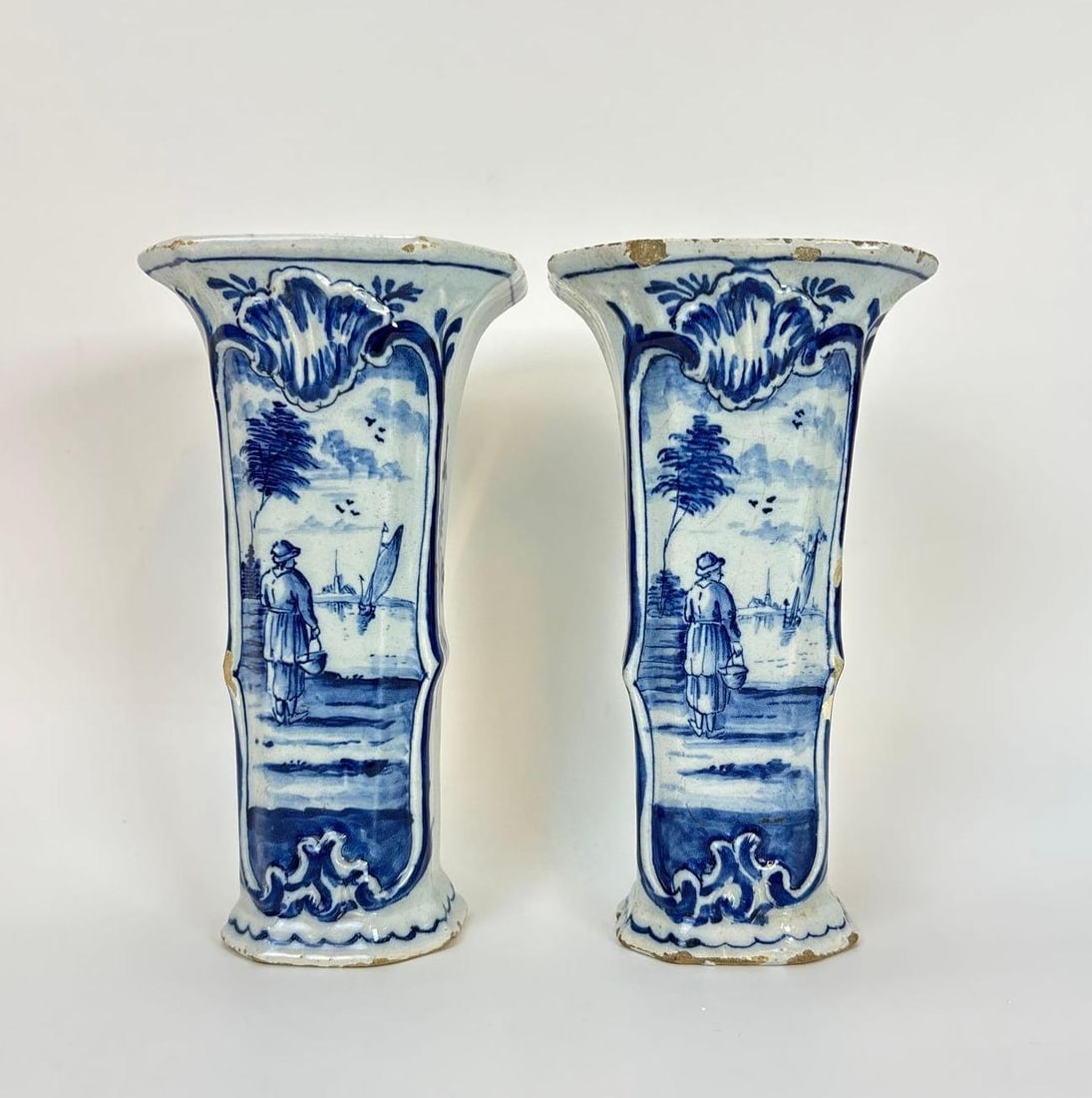 PAIR OF ANTIQUE 18TH CENTURY DUTCH DELFT BEAKER VASES: Tapering octagonal tin-glazed earthenware vases with flared rims and hand-painted blue and white Chinoiserie landscapes. Approximate Dimensions: 7"h x 4"w x 3 1/2"d Artist or Maker: Unkn