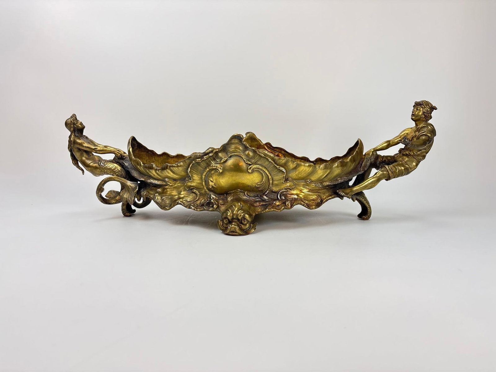 ANTIQUE FRENCH ROCOCO GILT BRONZE FIGURAL CENTERPIECE BOWL: Gilt bronze centerpiece with mythological mermaid and boy figural handles. Approximate Dimensions: 6.5" h x 21.5" x 9" Artist or Maker: Unknown Provenance: From a New York Collector N