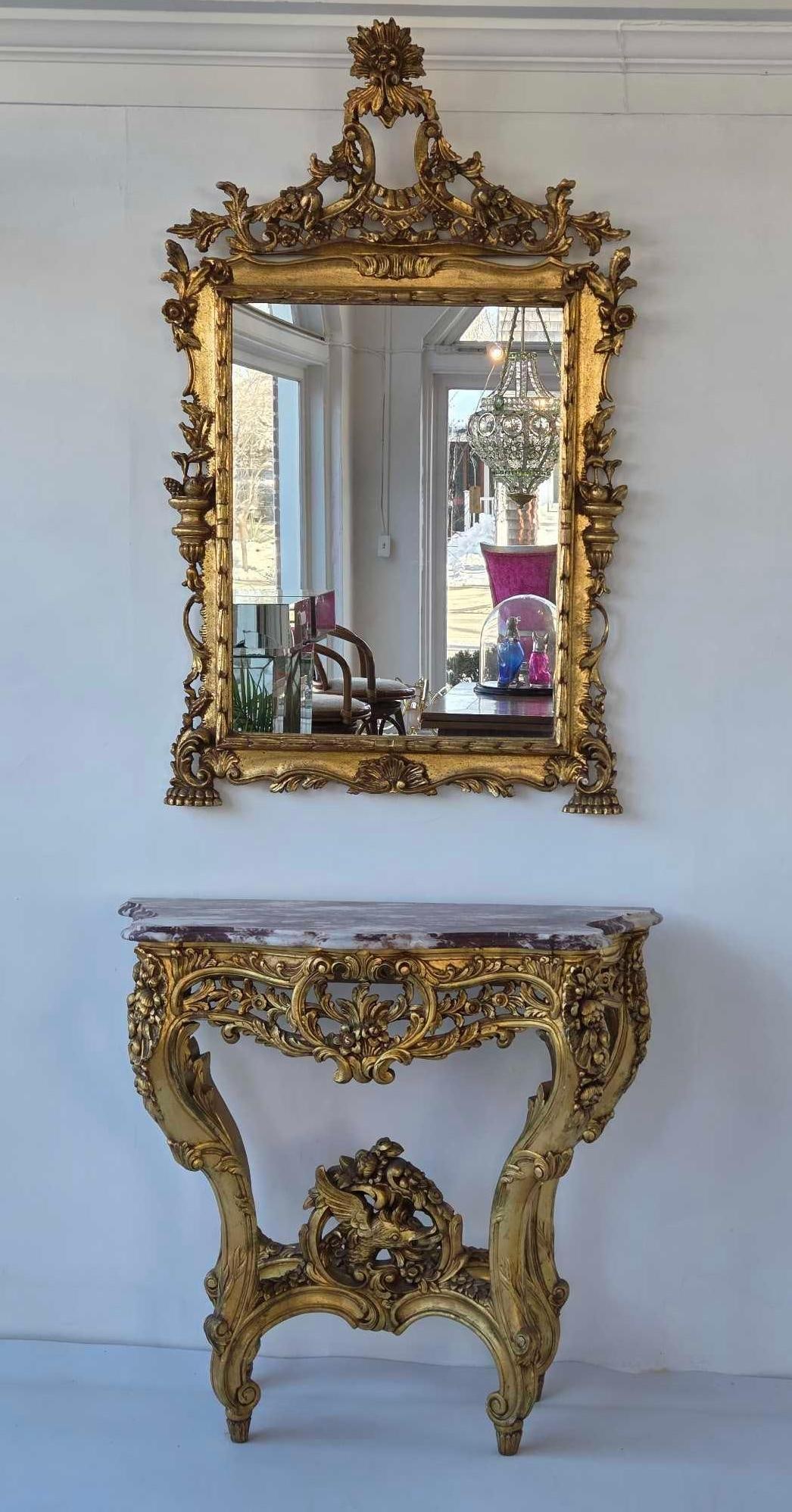 EXCEPTIONAL FRENCH LOUIS XV STYLE GILTWOOD MIRROR AND ROUGE MARBLE TOP CONSOLE: Carved gilt wood wall mirror with ornate floral crest paired with a matching marble-top console table on cabriole legs. Approximate Dimensions: 51"h x 32"w MIRROR; 34.25"h x 37"w x 15&