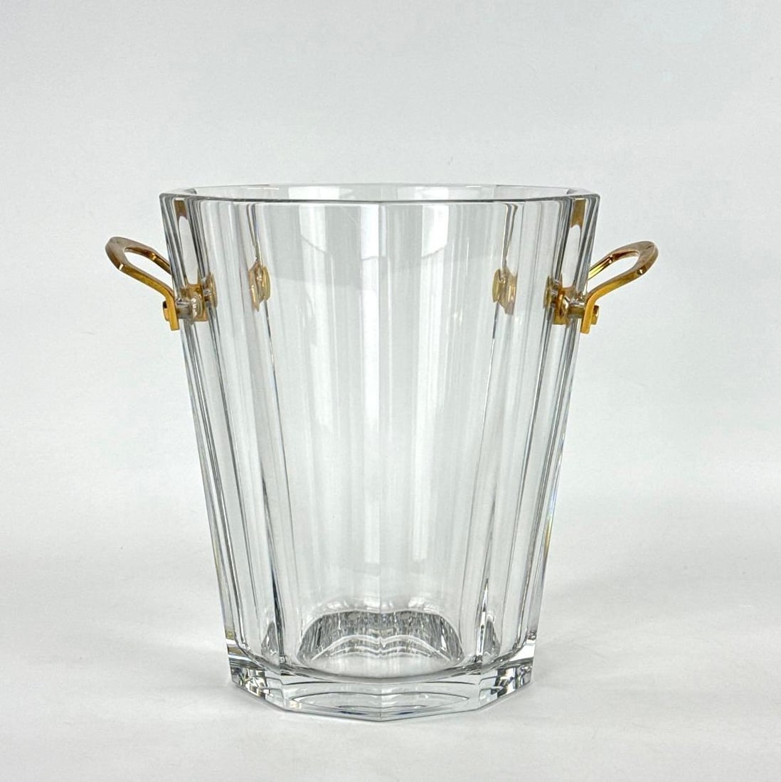 VINTAGE SIGNED BACCARAT FRANCE HARMONIE CUT CRYSTAL CHAMPAGNE BUCKET: Heavy octagonal tapered lead glass ice vessel with faceted sides and twin gilded brass handles Approximate Dimensions: 9”h x 8”dia Artist or Maker: Unknown Provenance: Fro