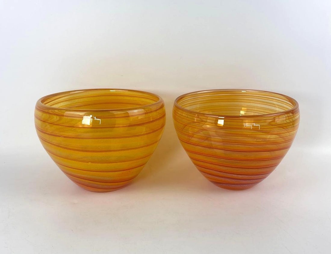 PAIR OF HENRY DEAN ART GLASS BOWLS/VASES: Two hand-blown amber glass vessels with horizontal orange line detailing and etched artist signature. Approximate Dimensions: 6.75"H x 9"Dia Artist: Henry Dean Provenance: From a New York C