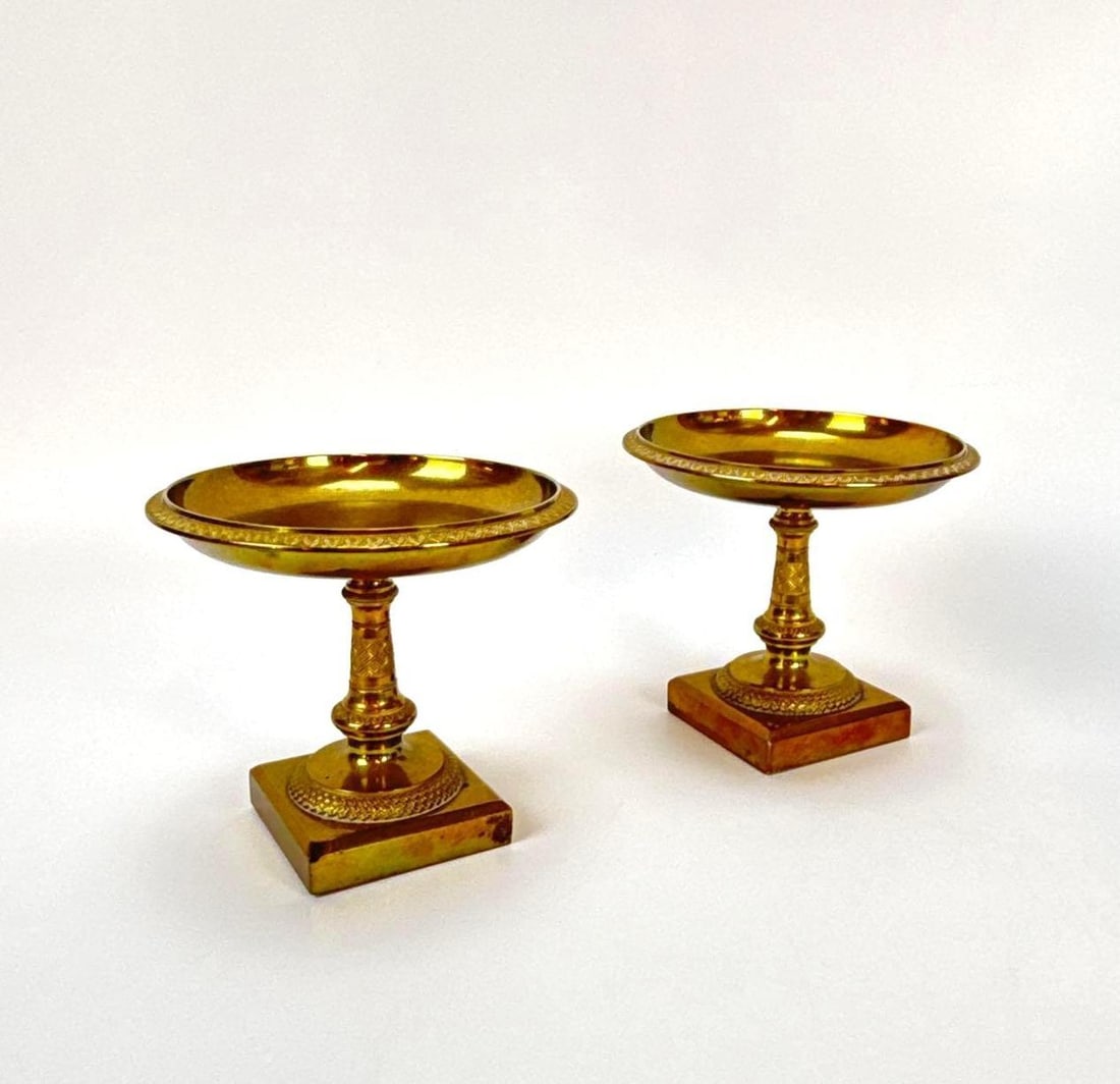 PAIR OF GILT BRONZE NEO RENAISANCE TAZZA CUPS: Matching set of two small pedestal dishes with decorative rim detailing and square bases. Approximate Dimensions: 4”h x 5.75”dia Artist or Maker: Unknown Provenance: From a New York Colle