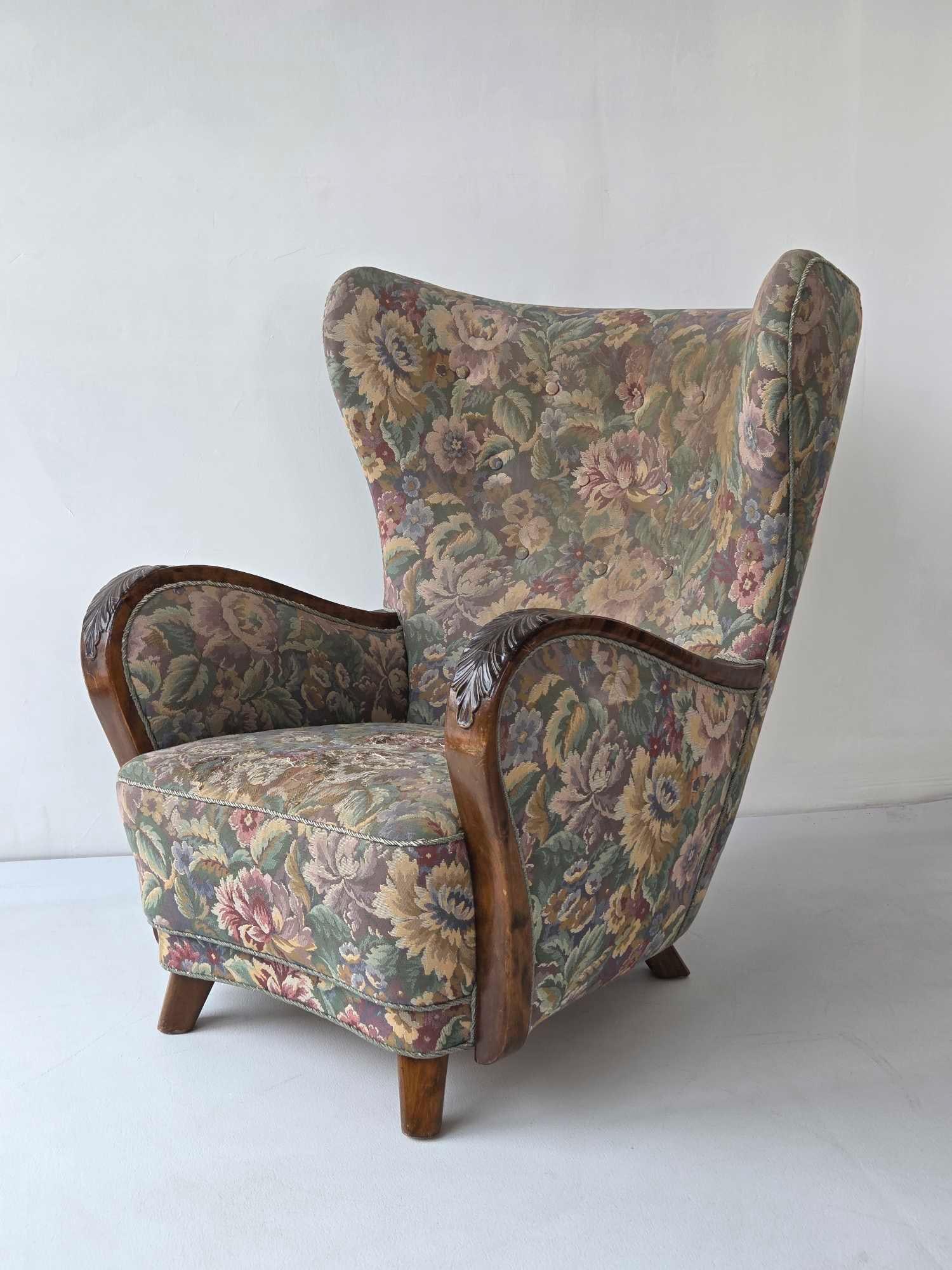 DANISH ART DECO WINGBACK LOUNGE CHAIR C. 1940'S: A mid-century wing back accent chair in a muted floral upholstery with hand-carved wood scroll arms and tapered block feet. Requires re-upholstery. Approximate Dimensions: 38.5"H x 31.75"W x