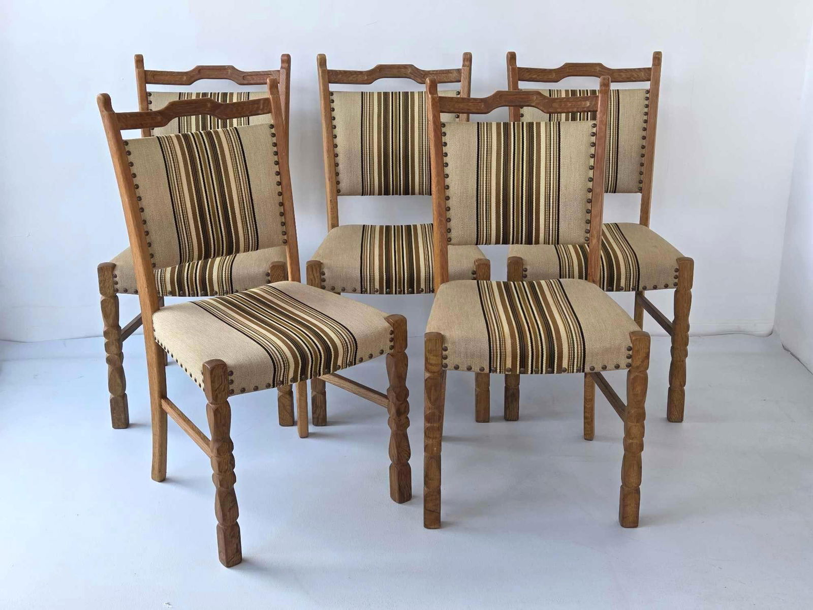 5 DANISH MODERN DINING CHAIRS IN THE STYLE OF HENNING KJAERNULF: Danish mid-century carved wood dining chairs with vertical striped upholstery and brass nail head detailing. Approximate Dimensions: 36"H x 18.75"W x 21"D Artist or Maker: Unknown Prove