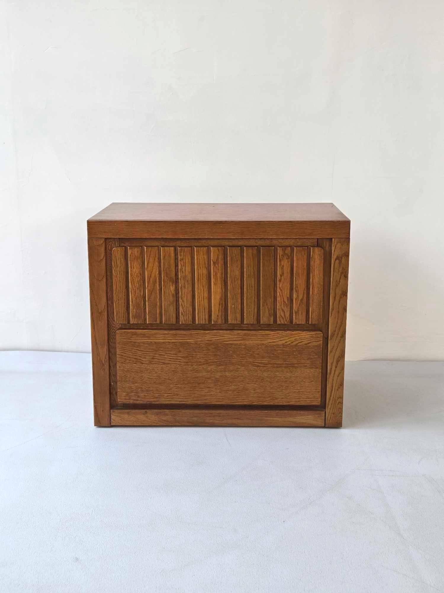 VINTAGE MID-CENTURY TWO DRAWER SIDE/END TABLE: Two-drawer bedside chest with vertical tambour-style carved relief top drawer and block frame construction. Approximate Dimensions: 22"H x 24.75"W x 16"D Artist or Maker: Unknown Proven