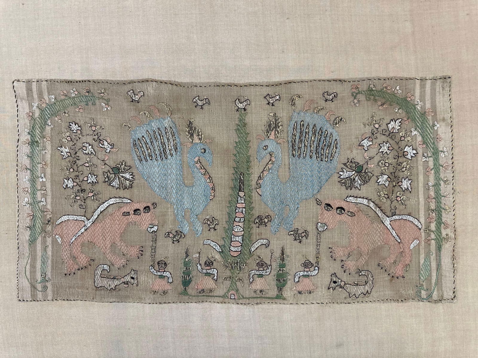 18TH CENTURY GREEK SAMOS SILK EMBROIDERY (1 of 2): Hand-stitched textile featuring upright floral stems and mythical creatures Approximate dimensions: 17.5”h x 27”w x .50”d Artist or Maker: Unknown Provenance:
