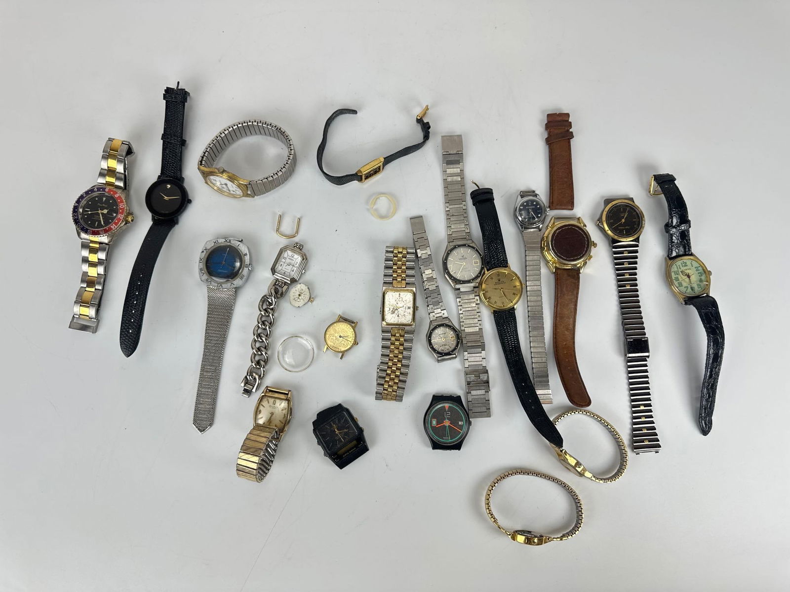 DISCOVERY LOT OF VINTAGE WATCHES: A diverse assortment of timepieces with various metal bracelets, leather straps, and loose watch parts. We cannot comment on working order. Maker: Various Provenance: From a New York Collector Note