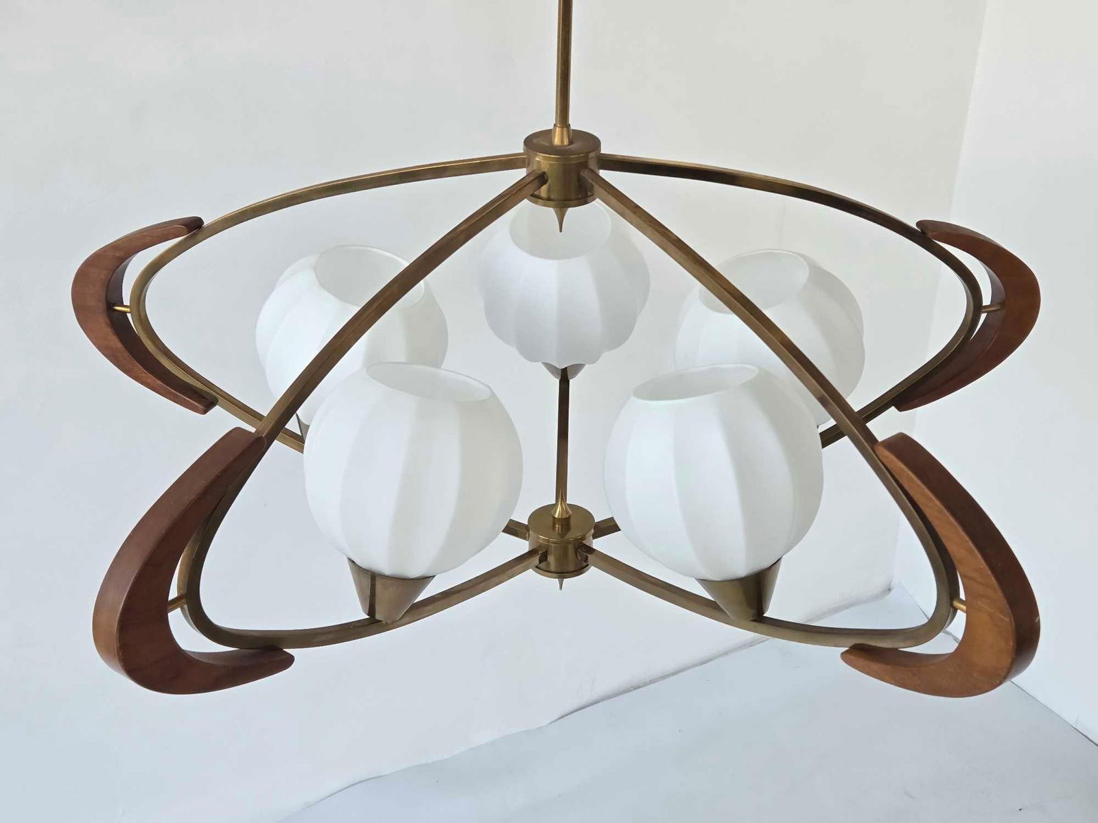 MID CENTURY MODERN ATOMIC STYLE BRASS AND WALNUT FIVE LIGHT PENDANT FIXTURE: A mid-century modern five-light hanging fixture constructed with solid brass and turned wood accents supporting frosted glass globes. Approximate Dimensions: 32"H x 31"Dia Artist or Maker: U