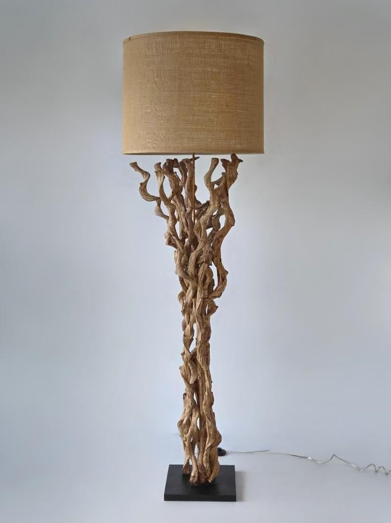SCULPTURAL BRANCH VINTAGE FLOOR LAMP IN THE STYLE OF MAITLAND-SMITH OR ROCHE BOBOIS: Large organic hand-twisted branch floor lamp mounted on a blackened square plinth with a neutral linen drum shade. Approximate Dimensions: 77"h; Shade 18"h x 24.5"dia Artist or Maker: