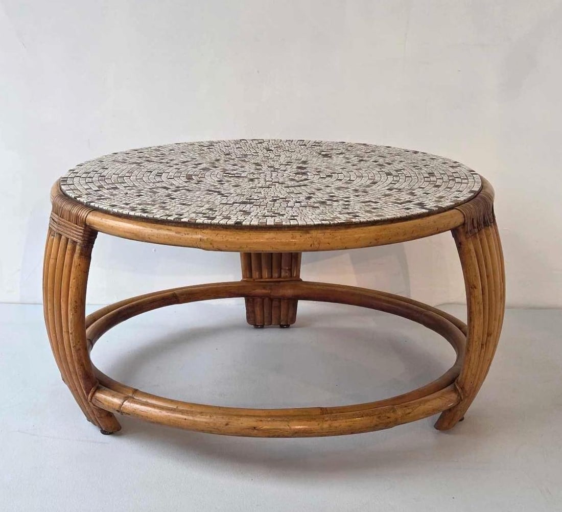 MID-CENTURY MODERN ROUND RATTAN COFFEE TABLE WITH MOSAIC TILE TOP: A circular bent rattan frame coffee table with a neutral mosaic tile top on three curved legs. Approximate Dimensions: 16.5"H x 31.5"Dia Artist or Maker: Unknown Provenance: From a