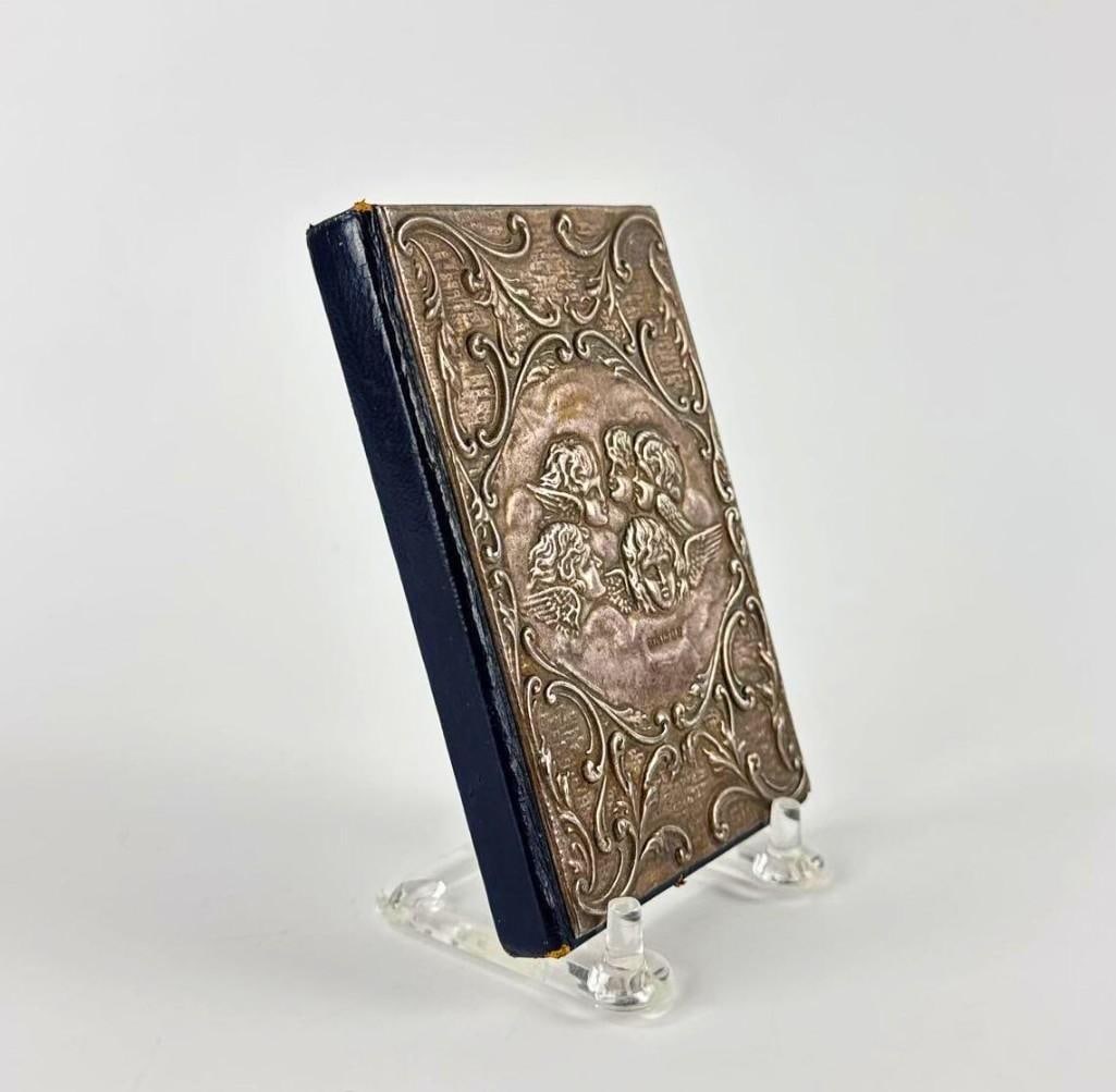 VICTORIAN STYLE STERLING SILVER AND LEATHER BOUND JOURNAL: Vintage address book featuring a hallmarked sterling silver front cover with ornate repousse scrollwork and floral motifs. Approximate Dimensions: .5” X 3” X 4.75” Artist or Maker: